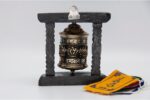 Tibetan prayer wheel with Ashtamangala embossing on copper and carved wood