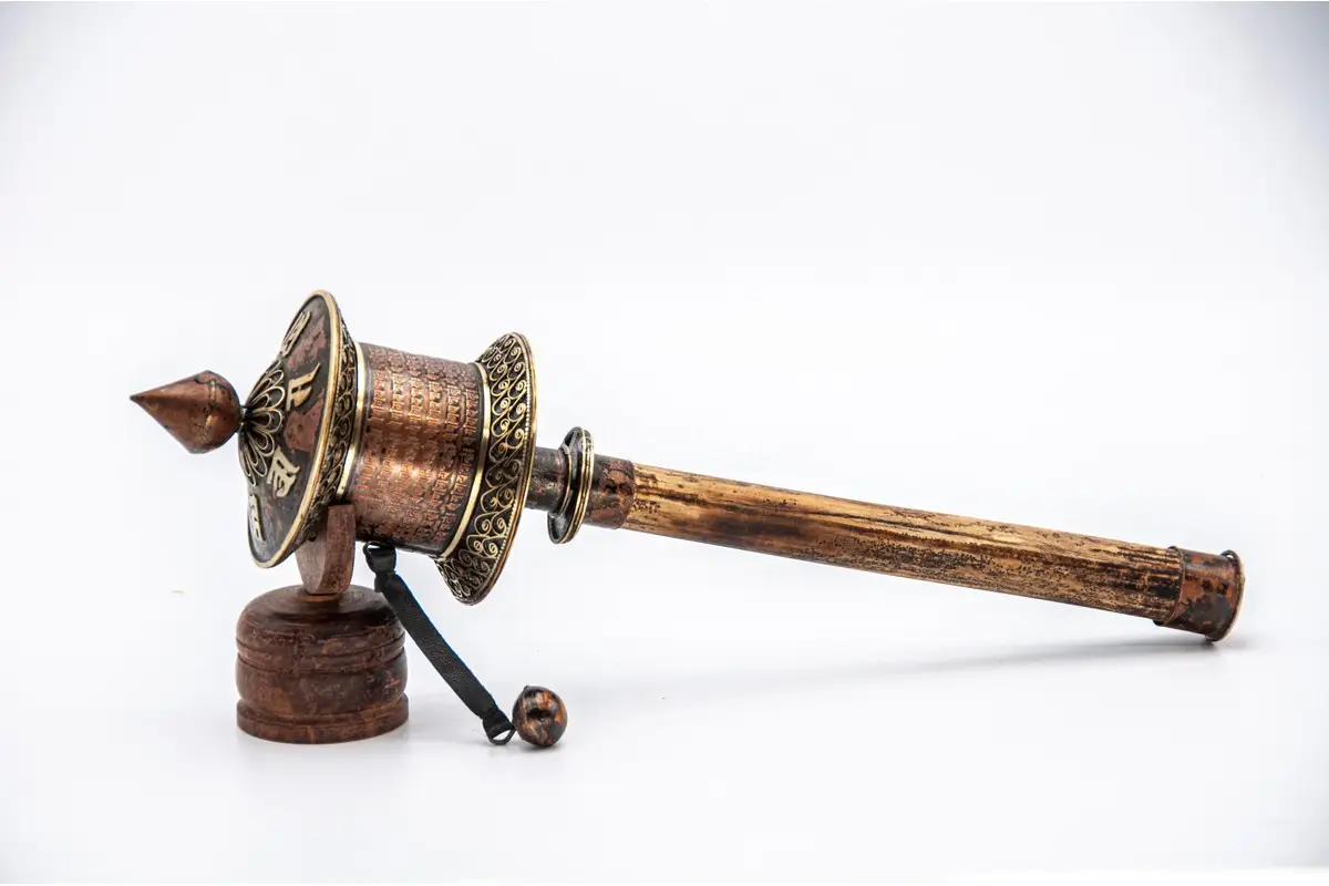Close-up of Om Mani Padme Hum engraved on copper prayer wheel