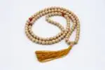 Lotus Mala with Red Coral Stone – handcrafted 108-bead prayer necklace featuring lotus accents and vibrant red coral beads, symbolizing passion, transformation, and spiritual awakening. Ideal for meditation, mantra chanting, and chakra healing.