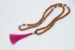 Rudraksha Mala with Pearl & Amethyst – handcrafted 108-bead prayer necklace combining sacred rudraksha seeds with calming pearl and spiritual amethyst, symbolizing protection, peace, and higher awareness. Ideal for meditation and spiritual growth.